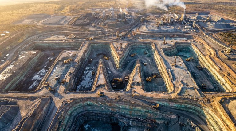 Terra Metals Ltd-TM1-Mining trucks in a vast open pit.