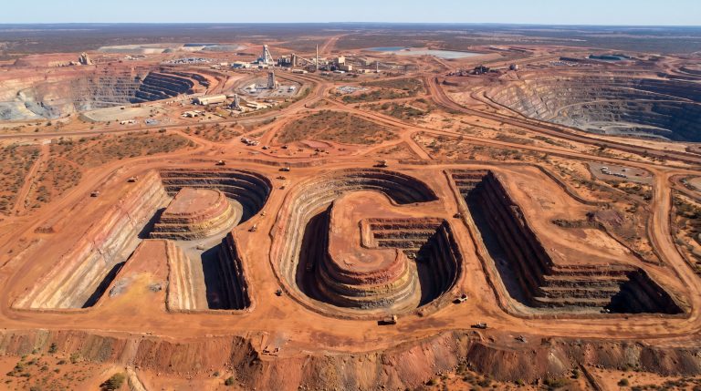 Riversgold Ltd-RGL-Open pit mine features sculpted letters.